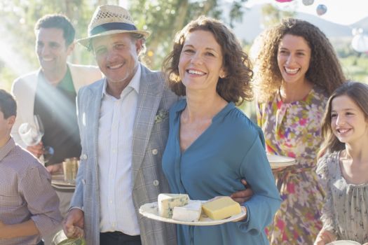 Smiling group enjoying food and drinks at an outdoor celebration, representing holiday party venues near Nashville.