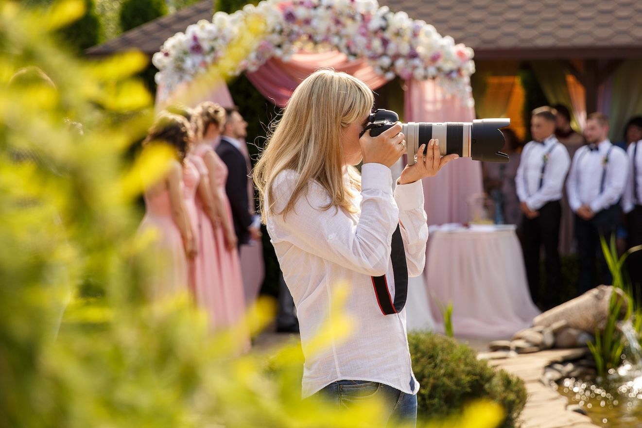 Photographer taking pictures at Rural Hill Farm during golden hour at an outdoor wedding.