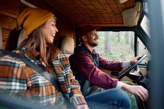 Happy couple driving their RV through Tennessee, enjoying fall RV camping near Nashville.