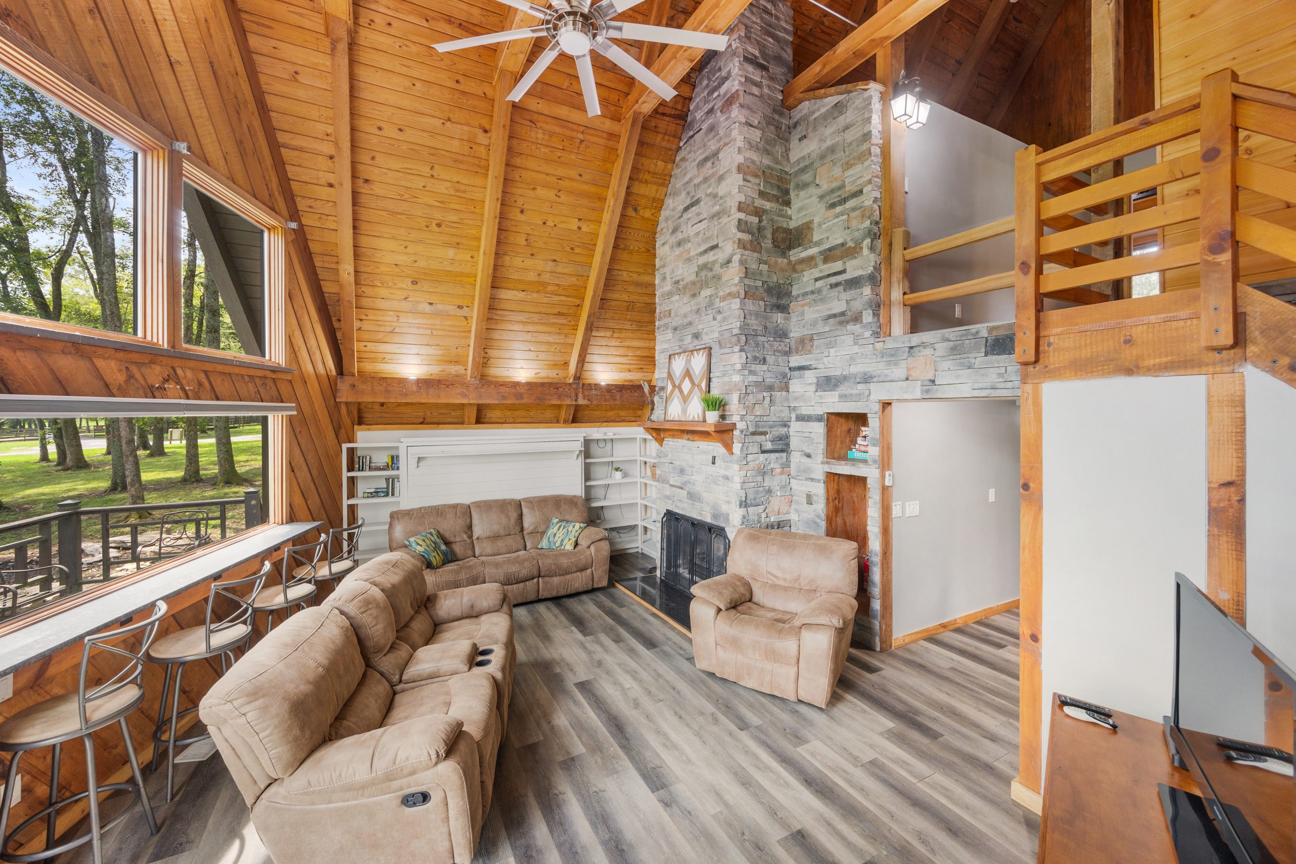 Cozy cabin living area with rustic wood beams, stone fireplace, and comfortable seating at Rural Hill Farm.