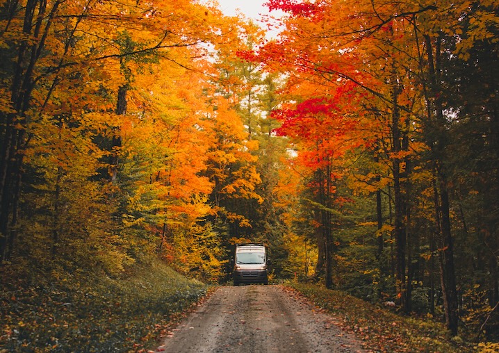 Scenic fall RV camping near Nashville Tennessee, with a camper van driving through colorful autumn foliage in Mt. Juliet
