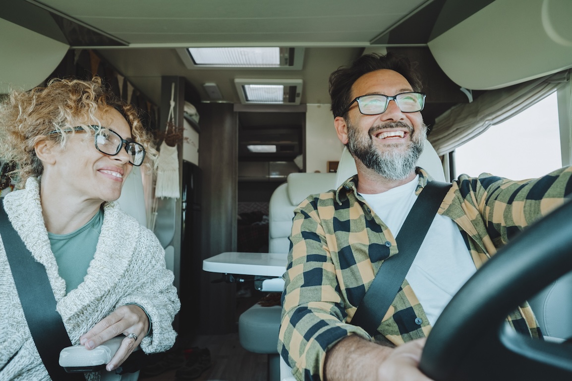 Happy woman and man driving their rv.