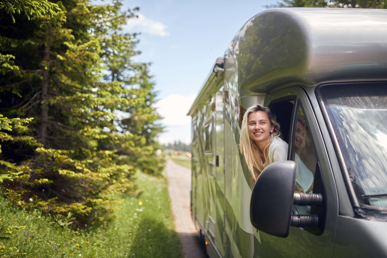 Woman enjoying RV travel experience during scenic road trip adventure