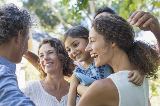 Large family hugging together during an outdoor family reunion