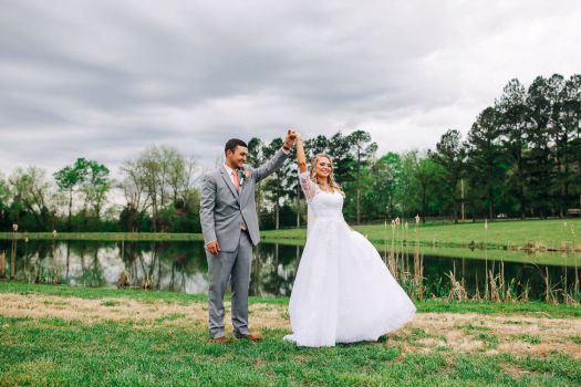 Couple celebrating outdoor wedding ceremony by pond at Rural Hill Farm wedding venue near Nashville
