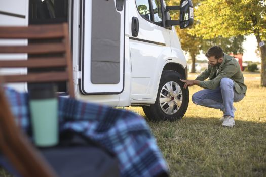 RV owner inspecting a tire before a camping trip.