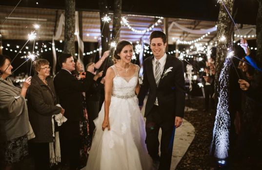 Newlyweds walking through a sparkler exit at a wedding reception at Rural Hill Farm