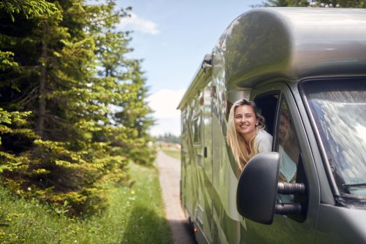 Woman enjoying RV travel experience during scenic road trip adventure