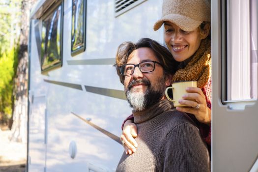 Couple enjoying coffee at their RV campsite during first RV camping trip